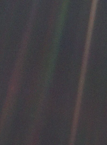 The Pale Blue Dot photograph: Earth as a tiny pale speck suspended in a band of scattered sunlight against the darkness of space