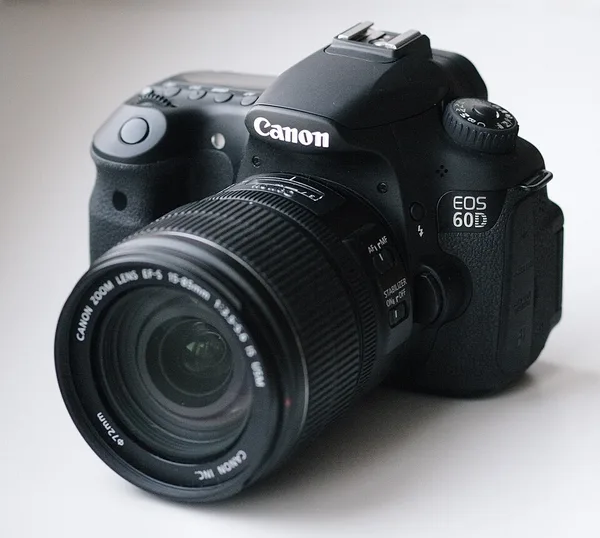 A black Canon EOS 60D with a 15-85mm zoom lens, seen from the front at an angle