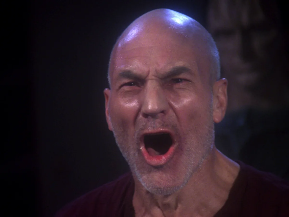 Picard, gaunt and in a rough dark red tunic, shouting in a dim Cardassian interrogation room
