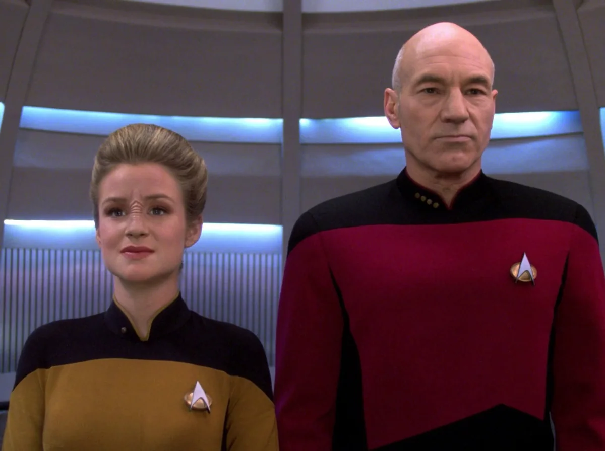 Ensign Sito Jaxa, a young officer in a gold uniform, standing beside Picard