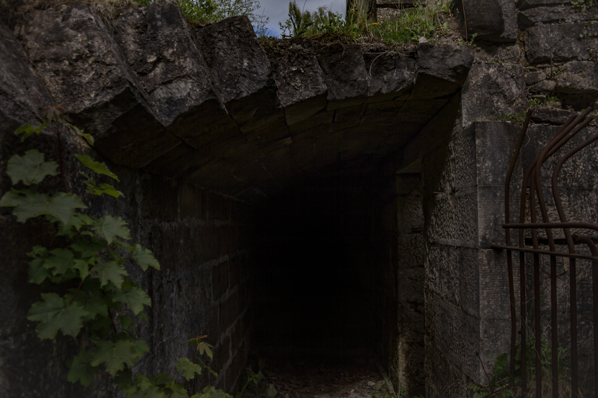 A stone tunnel entrance with darkness inside