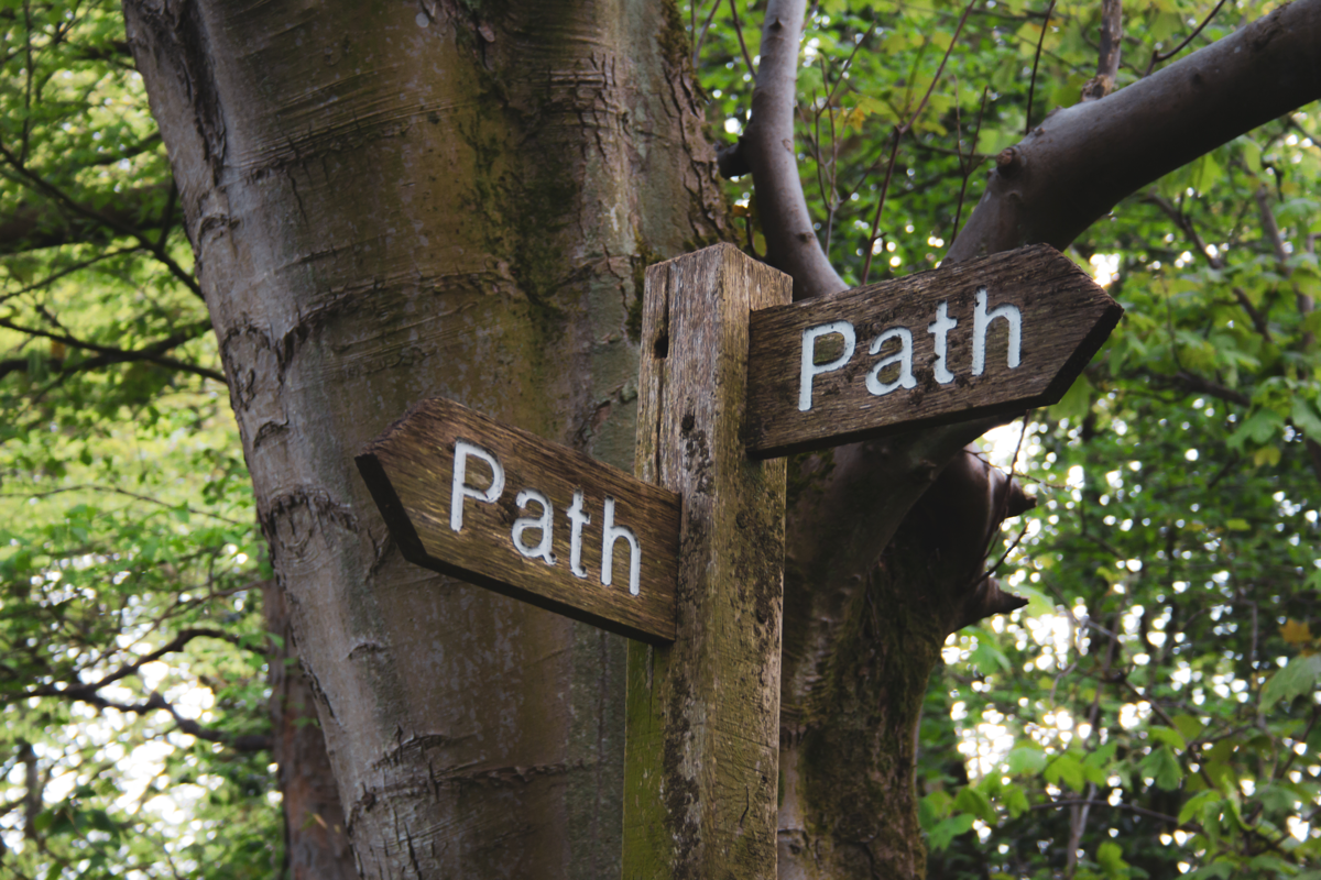 A signpost with ambiguous directions, both saying 'path'