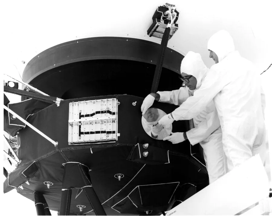 Technicians mounting the gold-plated Golden Record onto the Voyager 1 spacecraft in 1977
