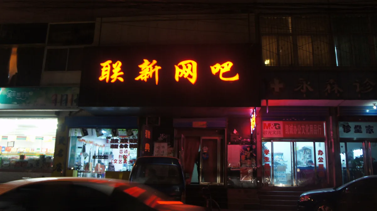 A neon sign for an internet cafe in China at night
