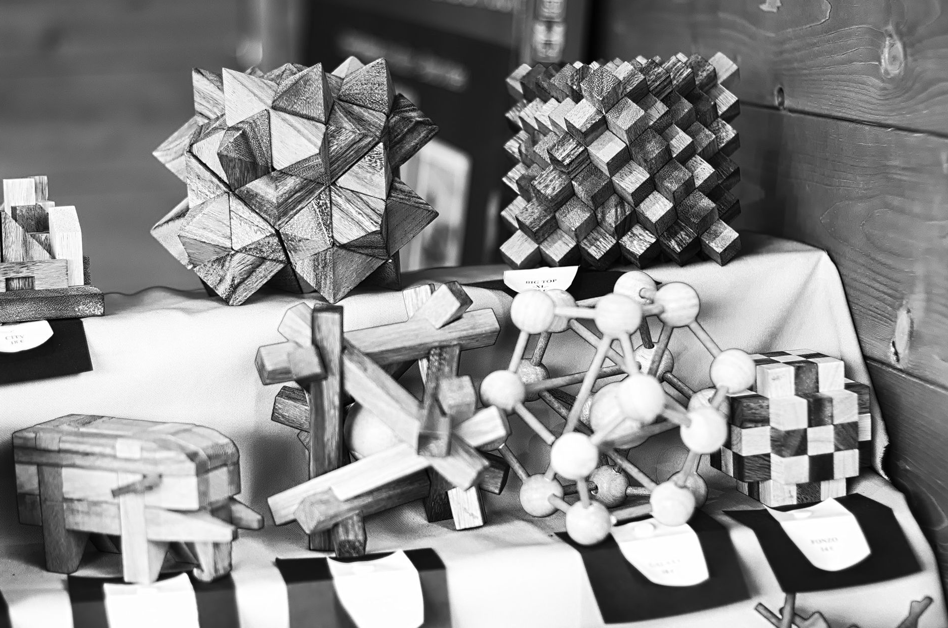A black and white photograph of geometric objects crafted from wood.