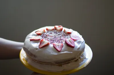 A strawberry cake being held up