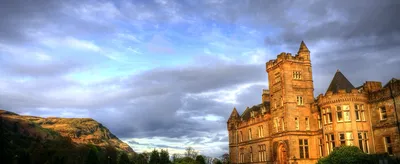 A sandstone castle building on the University of Stirling campus in late sun, under a cloudy sky