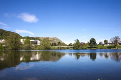 The loch on the University of Stirling campus under a blue sky